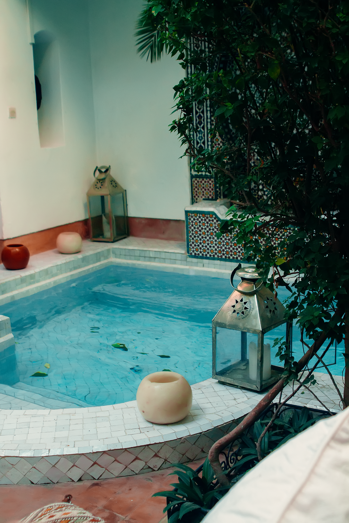 Courtyard pool with lanterns in a traditional Marrakech riad, evoking Riad Assakina's Mellah quarter setting